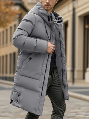 Man wearing a gray puffer coat on a city street