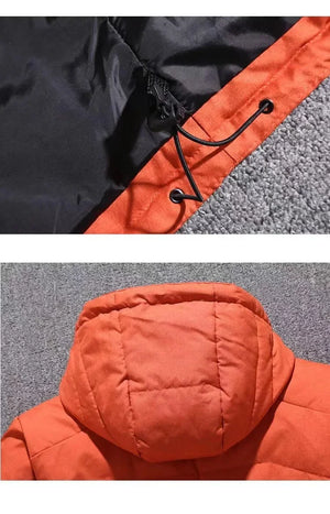 Close-up of a black and orange jacket with a hood on a gray surface.