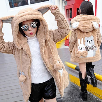 Beige plush coat with bunny designs worn by a person on a city street.