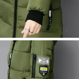 Green puffer jacket with black cuffs and patches on a gray background