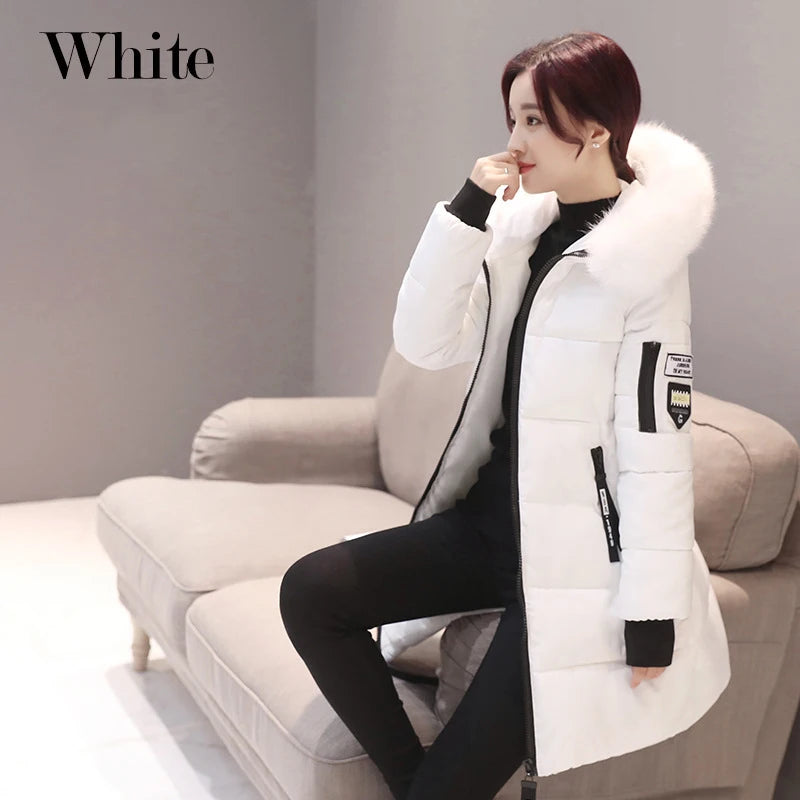 Person wearing a white winter coat sitting on a couch with a neutral background
