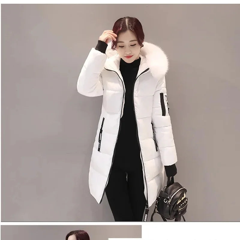 Woman wearing a white winter coat with fur hood on a gray background