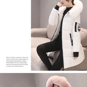 White winter coat with black accents worn by a person sitting on a couch.