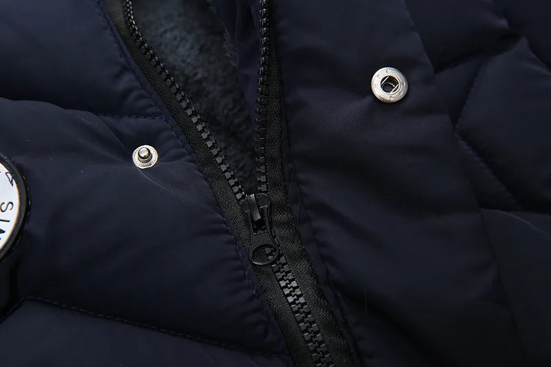 Close-up of a navy blue puffer jacket with zipper and button details.