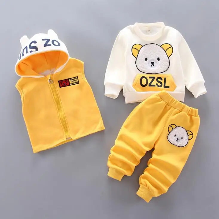 Children's clothing set with yellow vest, white shirt, and pants on a gray background