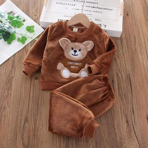 Children's brown fleece set with bear design on a wooden surface