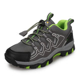 Gray and green hiking shoe with branding on a white background