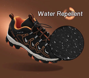 Black and orange water repellent shoe with close-up of sole showing water droplets on a brown background.