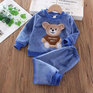 Blue children's fleece set with teddy bear design on a wooden surface