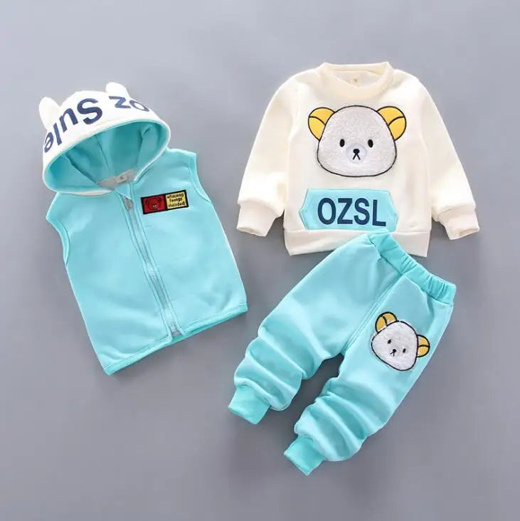 Children's clothing set with light blue vest, white shirt, and pants on a gray background