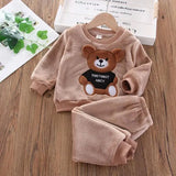 Children's brown fleece set with bear design on a wooden surface