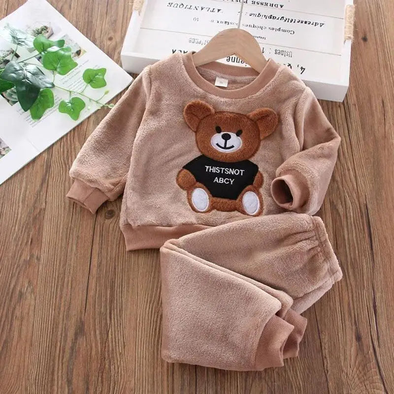 Children's brown fleece set with bear design on a wooden surface