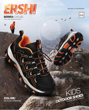Black and orange kids' outdoor shoes on rocks with branding.
