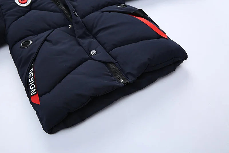 Folded navy blue puffer jacket with red accents on a light gray background