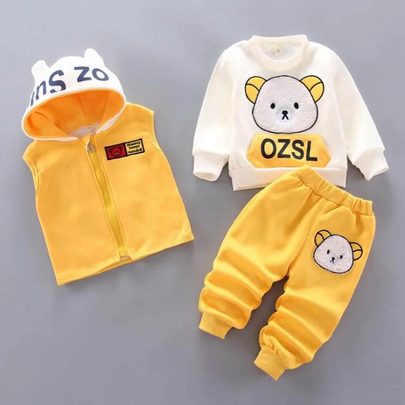 Children's clothing set with yellow vest, white hoodie, and yellow pants on a gray background