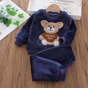 Navy blue children's outfit with teddy bear design on a wooden surface