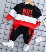 Children's outfit with black, red, and white design on a grid background