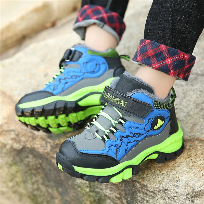 Children's blue and green hiking boots on a stone surface