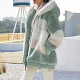 Person wearing a green and white sherpa jacket outdoors with blurred background