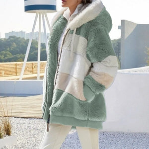 Person wearing a green and white sherpa jacket outdoors with blurred background