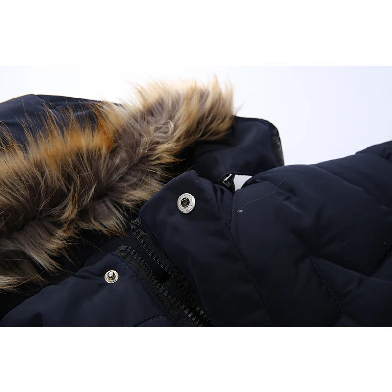 Close-up of a dark blue winter coat with a fur-lined hood on a light gray background
