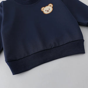 Navy blue sweatshirt with a small bear emblem on a light gray background