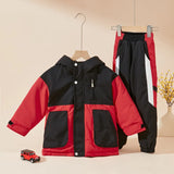 Red and black jacket and pants set on hangers with a small toy car on a beige background