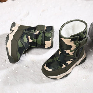 Camouflage-patterned boots with white fur lining on a snowy background