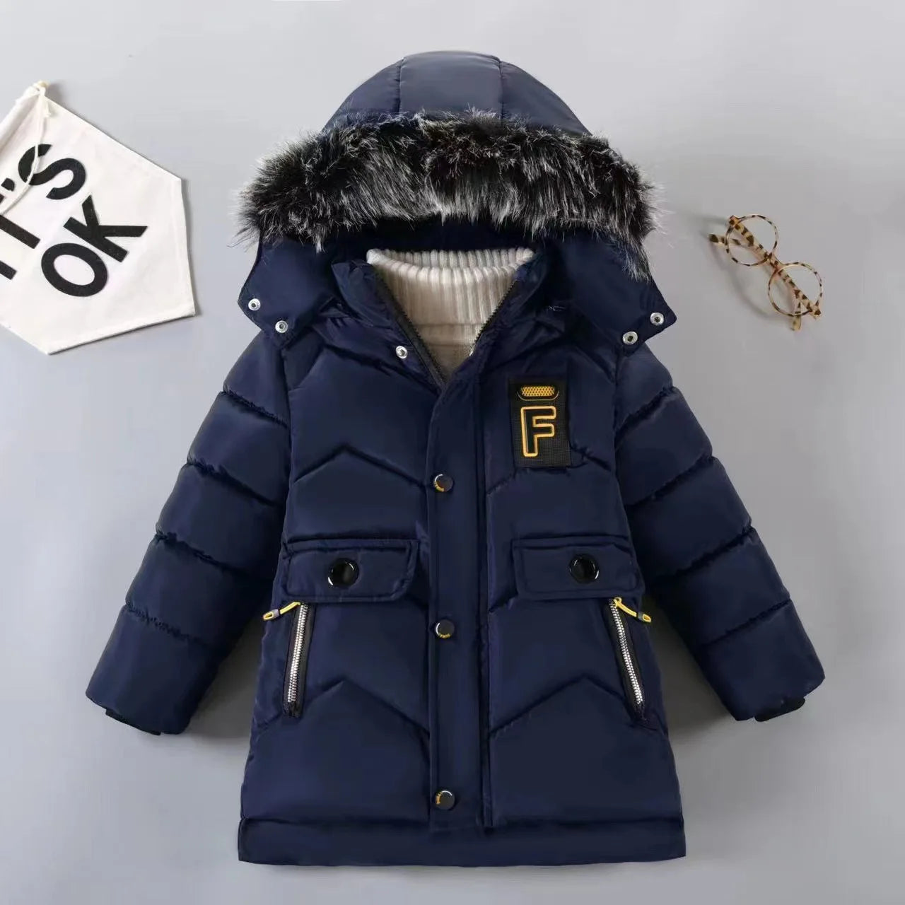 Navy blue children's puffer jacket with fur hood on a light gray background