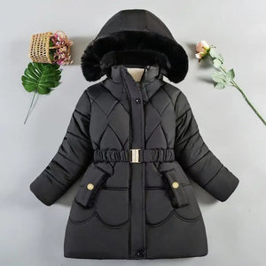 Black quilted winter coat with fur hood on a light gray background