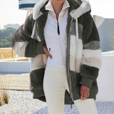 Person wearing a fur-lined coat with a white shirt and pants on a rooftop.