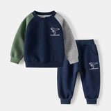 Children's navy and green sweatshirt and pants set with dinosaur design on a white background