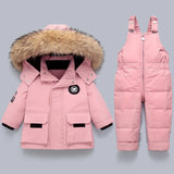 Pink winter coat with fur hood and pink snowsuit on a light gray background