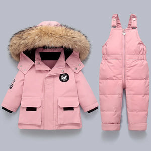 Pink winter coat with fur hood and pink snowsuit on a light gray background