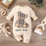 Baby romper with plaid bear design and 'mini bear' text on a wooden surface.