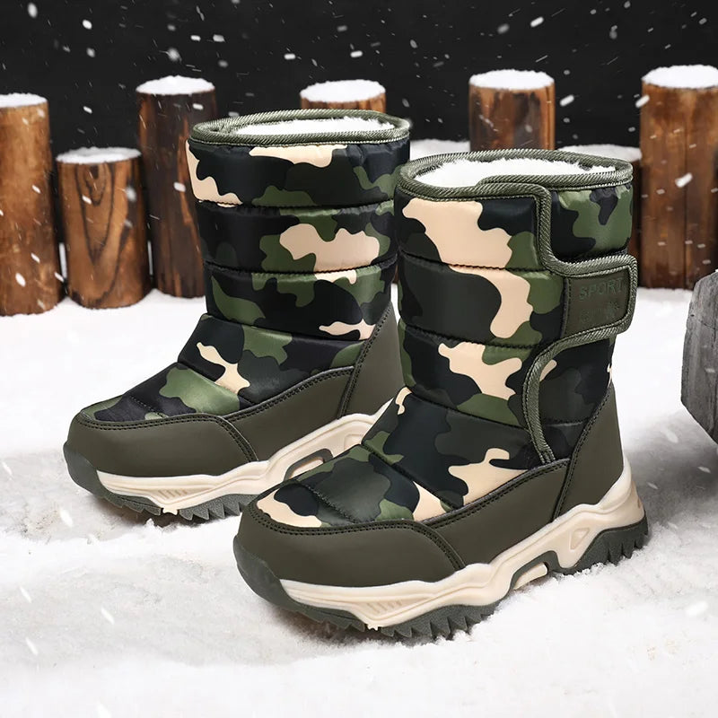 Camouflage winter boots in the snow with wooden logs in the background