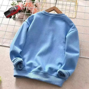 Light blue sweatshirt on a hanger with a toy car and flowers in the background
