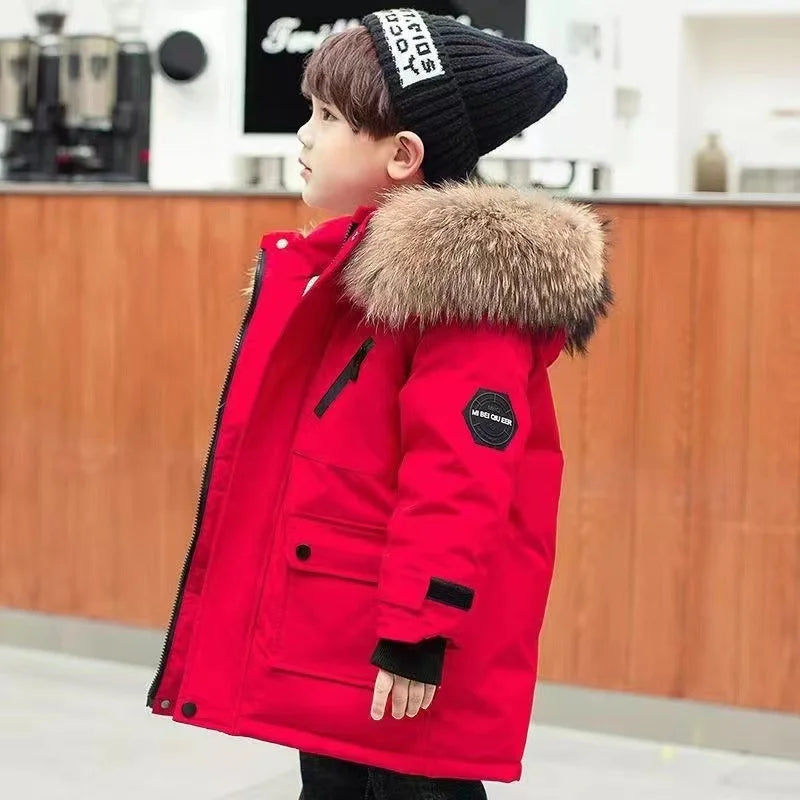 Child wearing a red winter coat with fur hood in an indoor setting