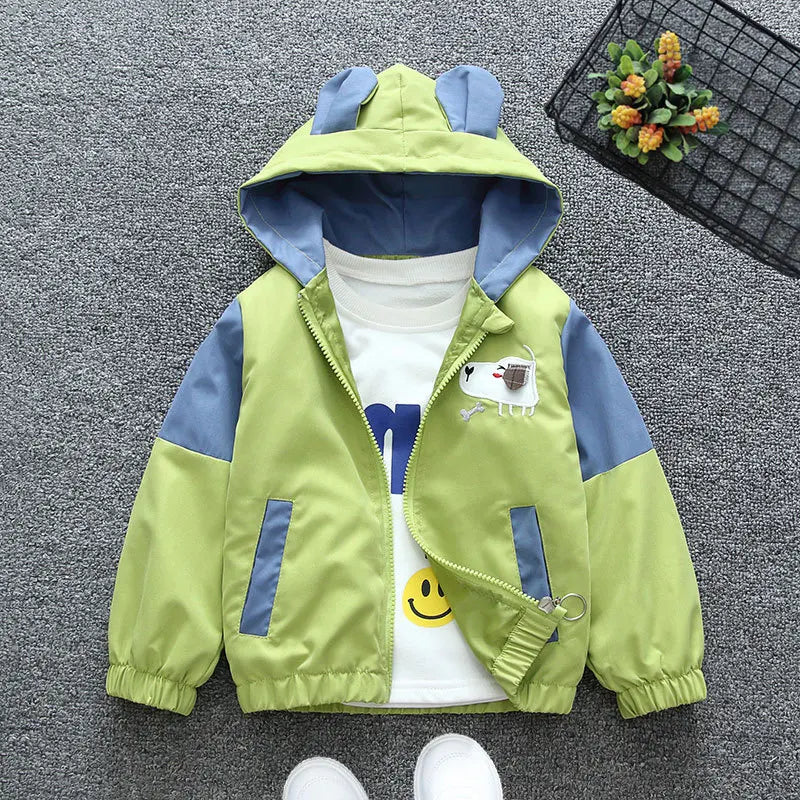 Children's green and blue jacket with cartoon design on a gray surface