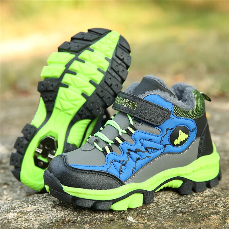 Pair of children's hiking boots with green, blue, and gray colors on a natural background.