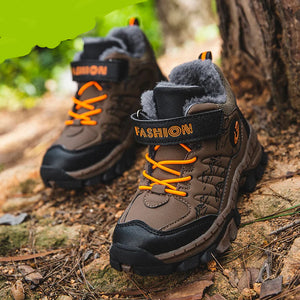 Brown hiking boots with orange laces on a natural background