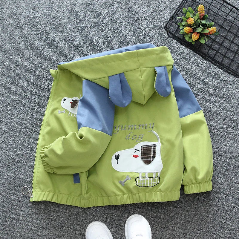 Green children's jacket with cartoon design on a gray carpet