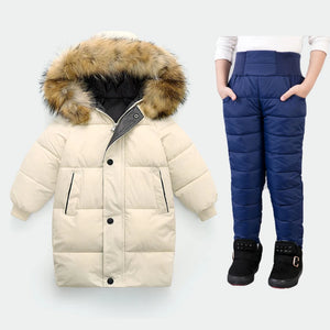 Beige winter coat with fur hood and blue snow pants on a white background