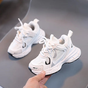 White sneakers with a brand logo held by a hand on a reflective surface