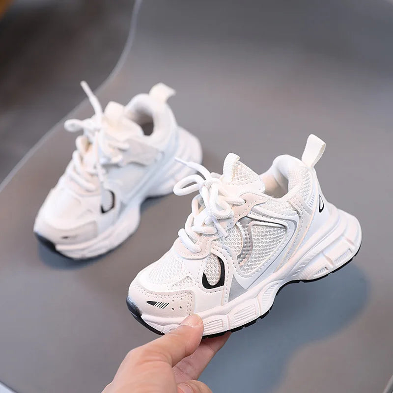 White sneakers with a brand logo held by a hand on a reflective surface