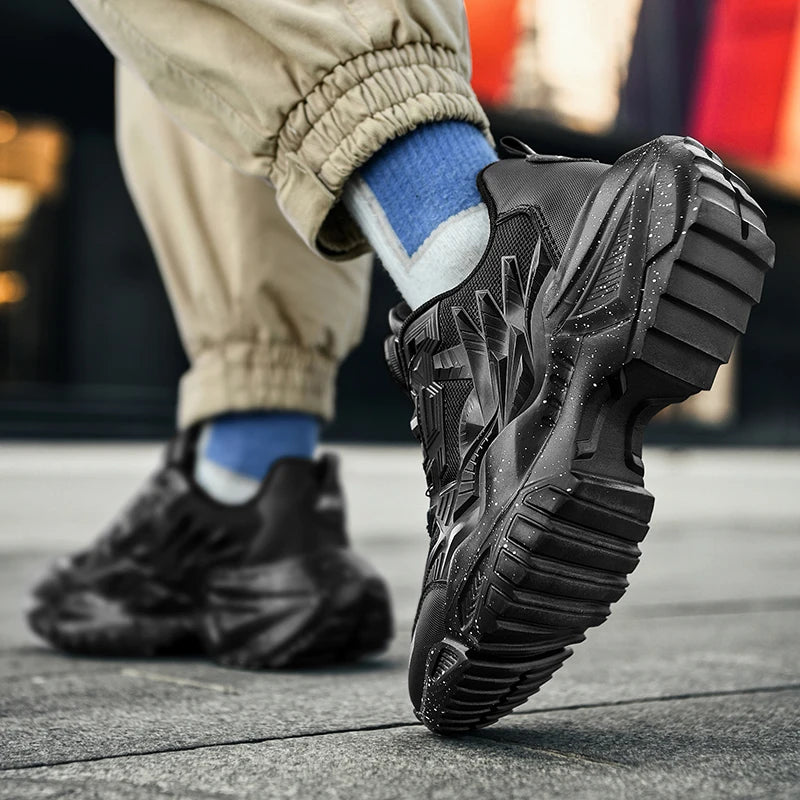 Black athletic shoes with thick soles worn by a person on a blurred background