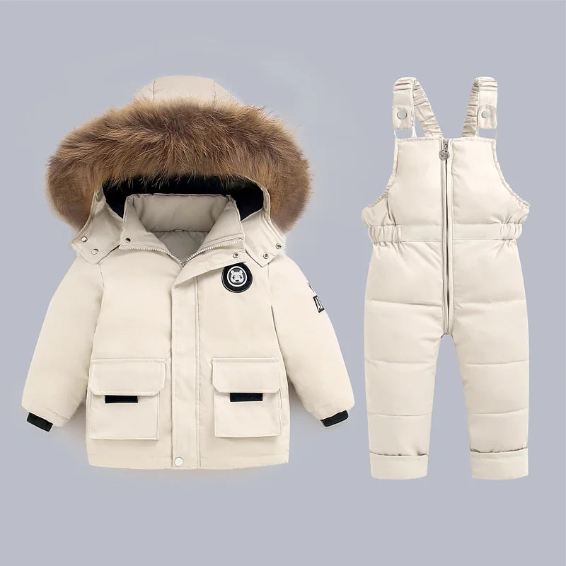 Children's winter outfit with coat and snowsuit on a light gray background