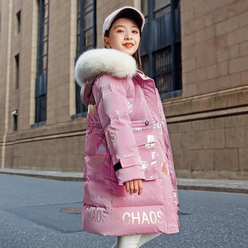Child wearing a pink puffer coat with fur hood in an urban setting