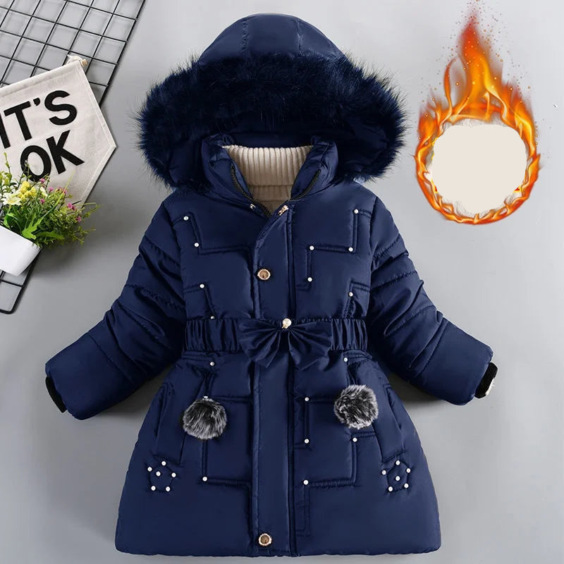 Blue winter coat with fur hood on a light gray background