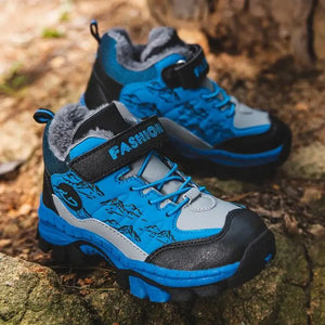Blue and gray children's hiking boots with mountain design on a natural background